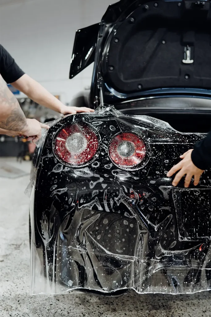 Front-end collision damage on a luxury vehicle being assessed at Enthusiast Auto Works