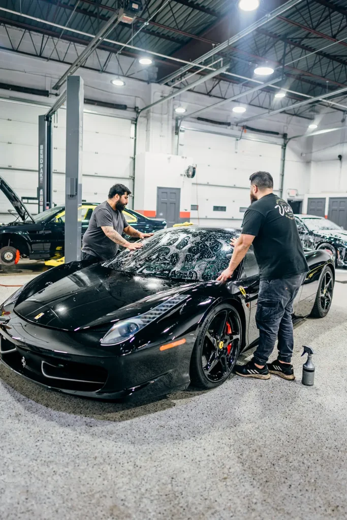 Technicians finishing a Ferrari at Enthusiast Auto Works collision center